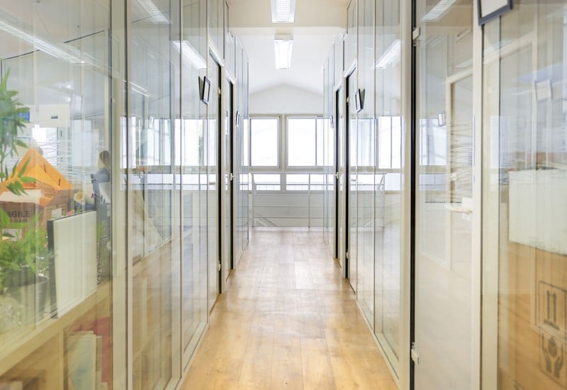 Couloir de bureaux avec des cloisons vitrées toute hauteur